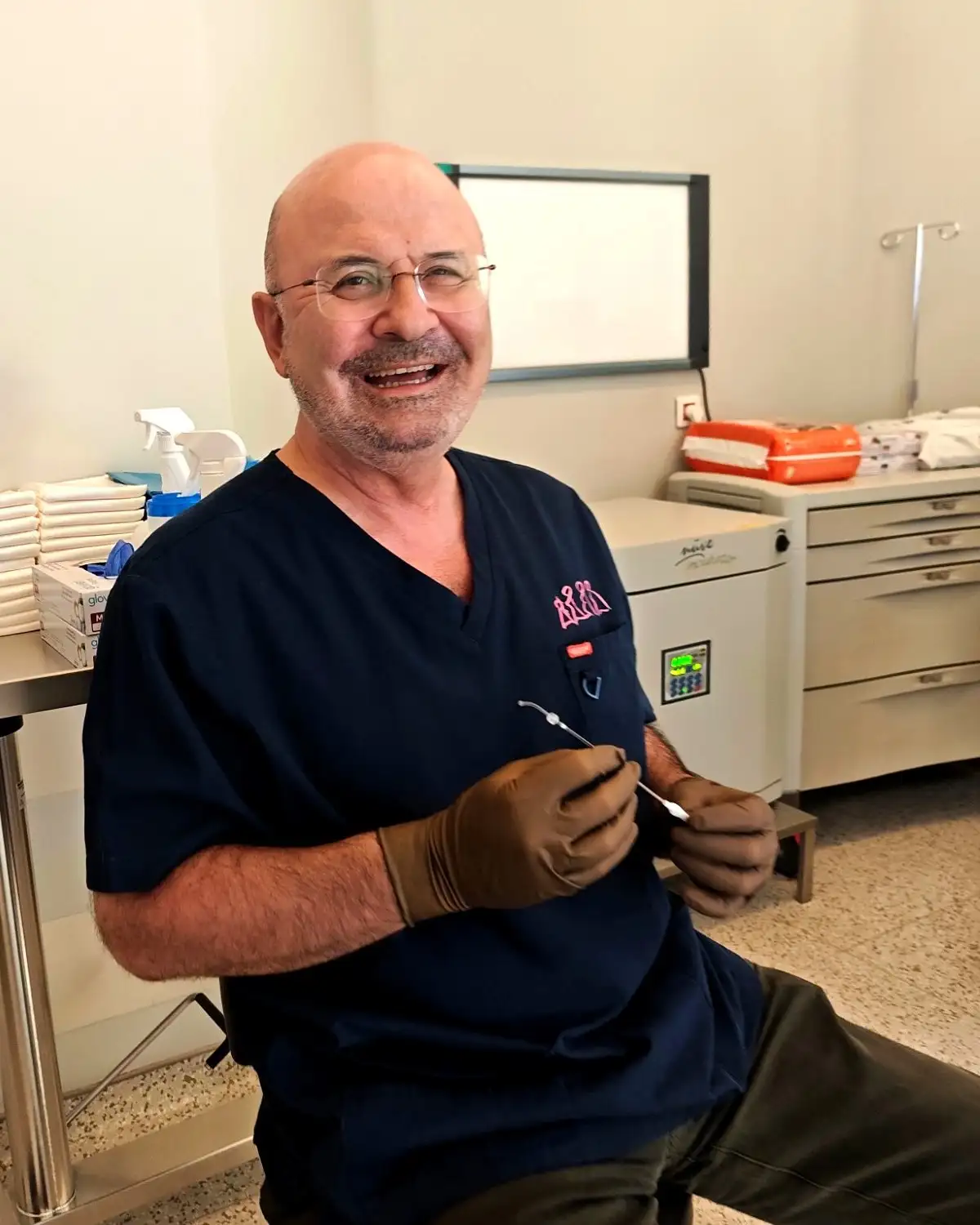 Dr. Senai Aksoy in the procedure room, holding an embryo transfer catheter